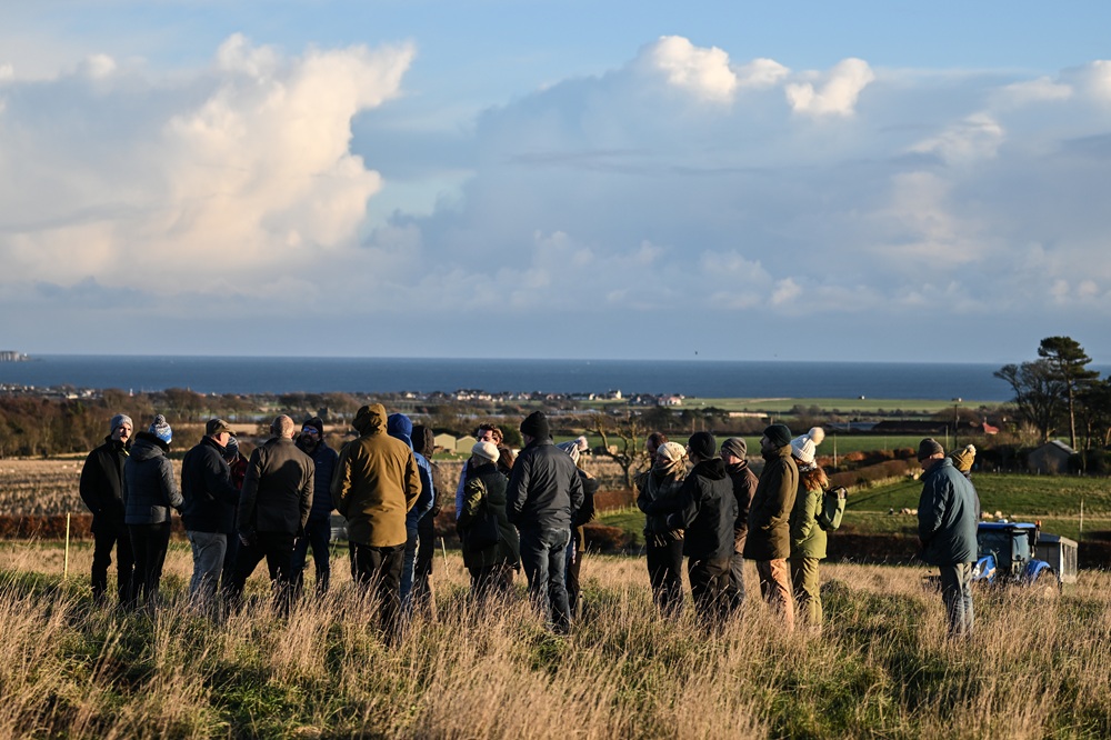 A group of people having a conversation in a field